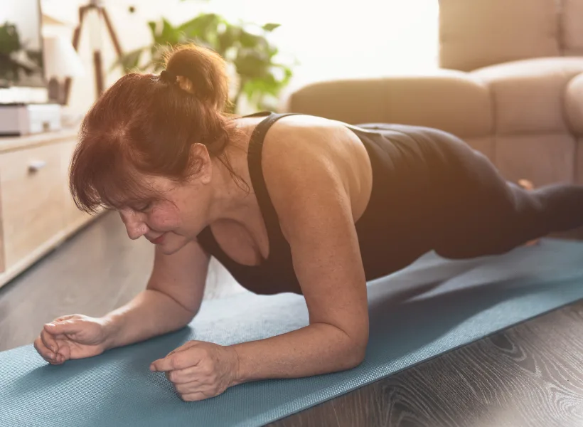 woman doing plank for core workout in living room