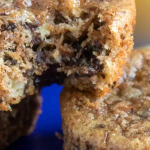 stacked chocolate chunk muffins on a blue plate