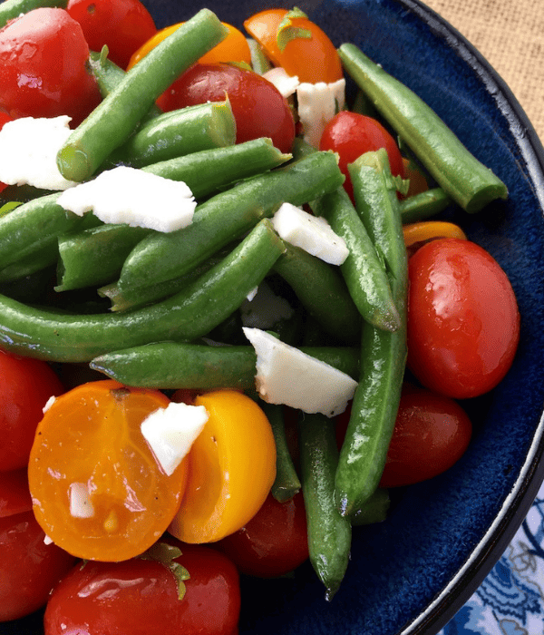 salad with green beans, tomatoes and feta cheese in bowl