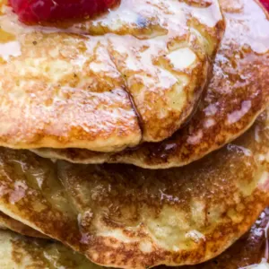 pancakes with syrup and fruit on plate