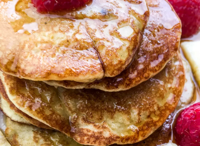 pancakes with syrup and fruit on plate