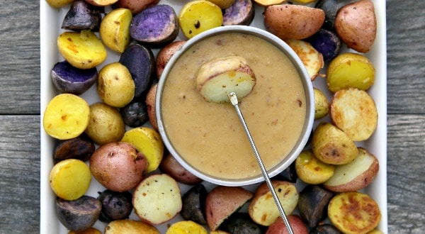 irish potato fondue with skewers and potatoes cooked and cut into bite sized pieces on a serving platter
