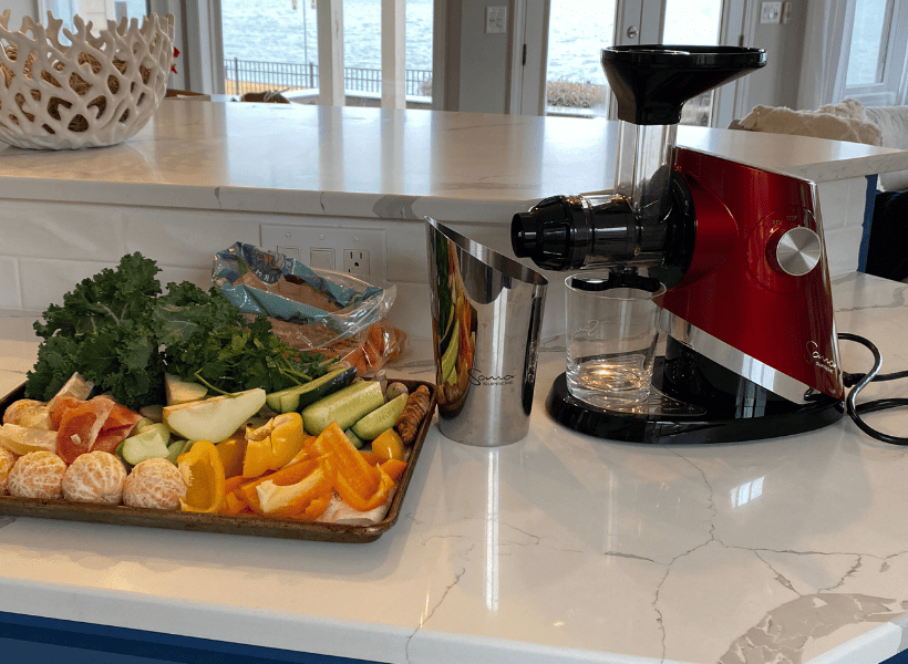 sana 727 juicer with fruits and vegetables beside it
