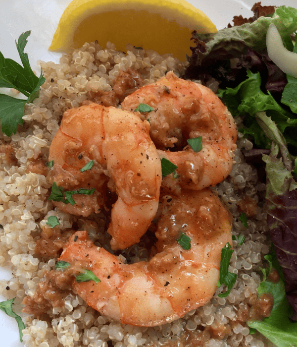 shrimp scampi without wine on bed of quinoa with salad on plate