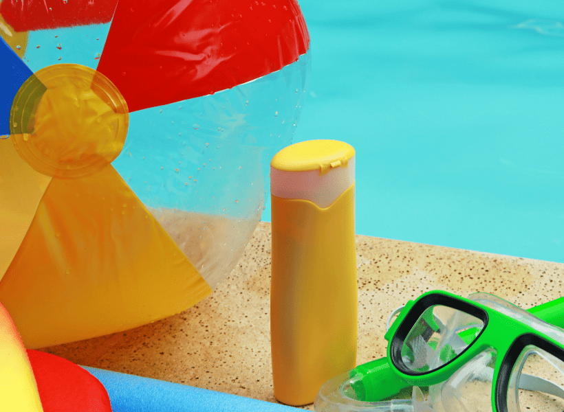 swimming supplies by the pool beach ball goggles and pool noodle