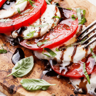 caprese salad on cutting board with fork