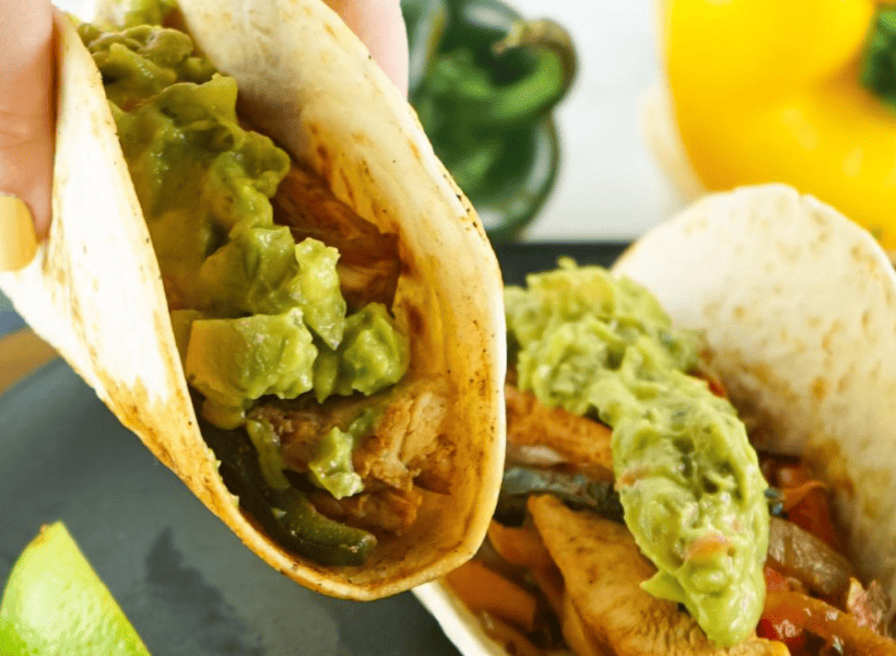 perfect flour tortilla filled with chicken fajitas and gaucamole