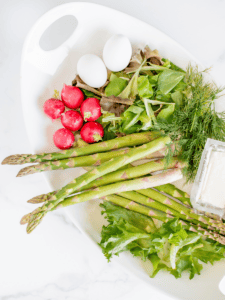 eggs, radishes, asparagus, lettuce and buttermilk on a plate ready to make healthy salad