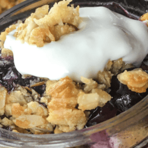 glass cup of gluten free blueberry crisp topped with oats