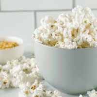 popcorn in a gray bowl with overflowing onto counter