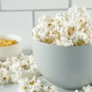 popcorn in a gray bowl with overflowing onto counter