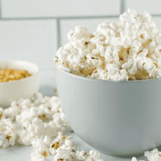 popcorn in a gray bowl with overflowing onto counter