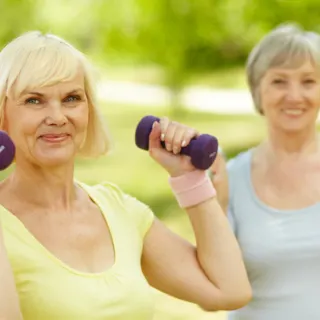two women outside one with handweights in hands