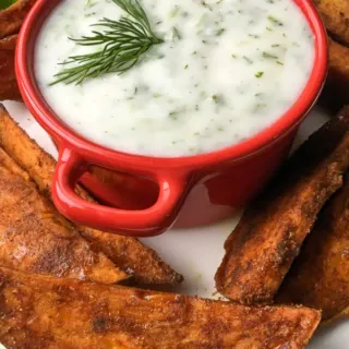 red dish with greek yogurt with potato wedges
