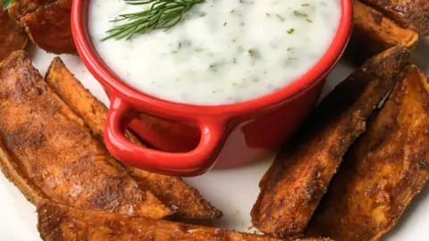 red dish with greek yogurt with potato wedges