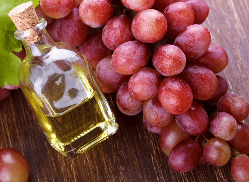 red grape seed oil with red grapes beside it