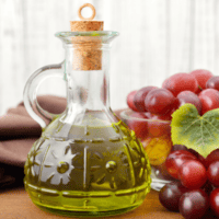 grapeseed oil in bottle on cutting board with grapes