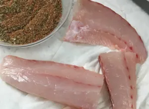 raw fish on platter with bowl of seasoning beside