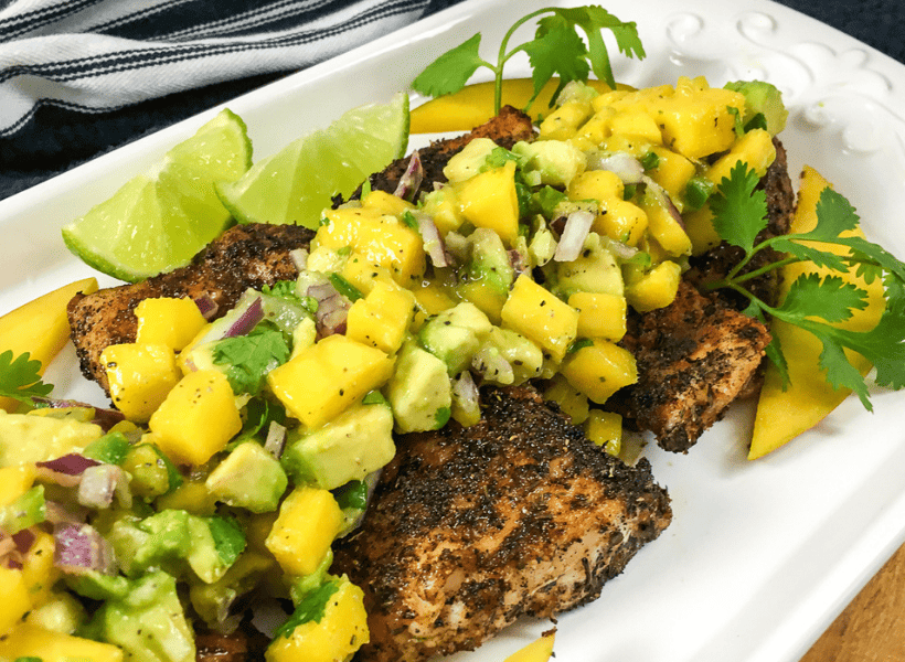 large serving plate with pan seared fish and mango salsa