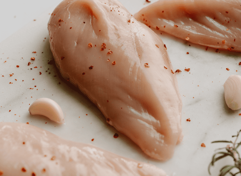 seasoned raw chicken on cutting board