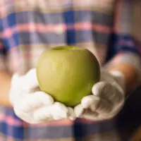 Close up of female hand holding green apple, healthy food, fruits