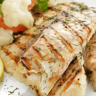 cooked fish on plate with potatoes