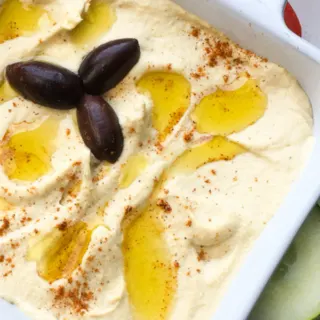 homemade garlic hummus with kalamata olives garnishment