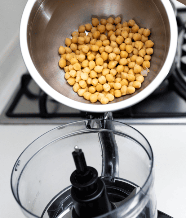 chickpeas being poured into food processor