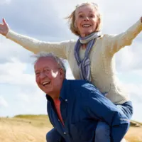 man and woman outside with man carrying woman on his back
