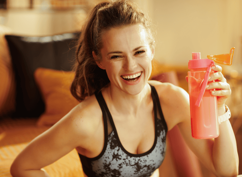 woman smiling with shaker bottle in hand