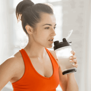 woman with shaker bottle of bcaas in hand