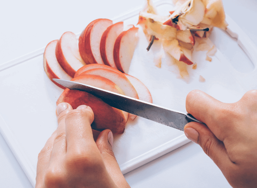 red apples being sliced on cutting board