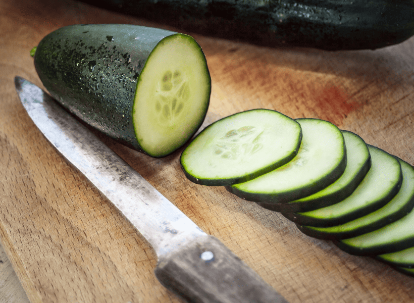 cucumber slices on cutting board with knife