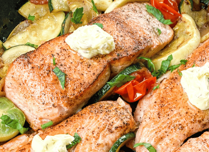 salmon with butter served over vegetables