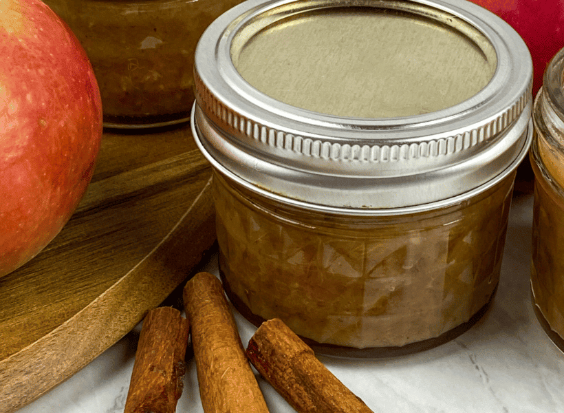 cinnamon sticks beside closed jar of apple chutney