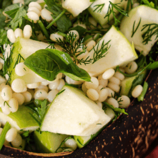 israeli pearl couscous recipe in a bowl with apples and herbs
