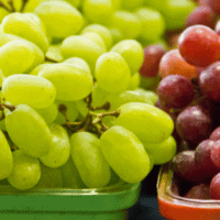 fresh green and red grapes in container