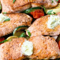 cooked salmon with vegetables in a cast iron skillet
