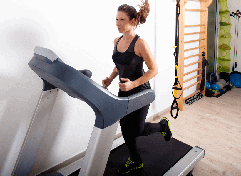 woman running on treadmill at home gym