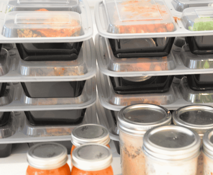 two stacks of meal prepping containers filled with food