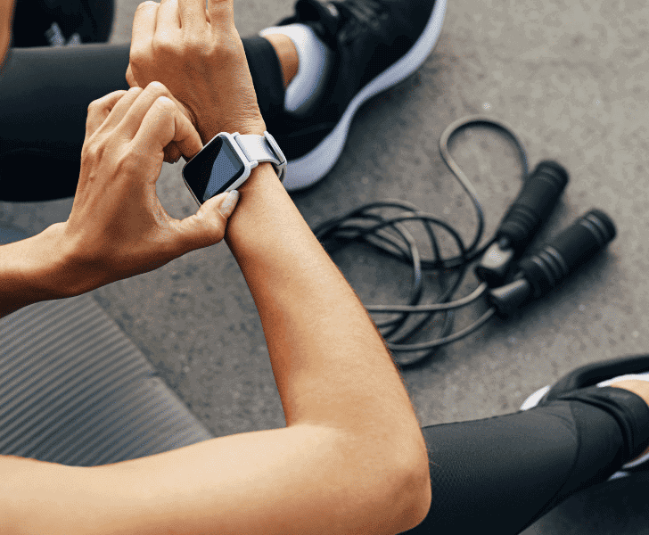 woman in fitness clothing adjusting her apple watch