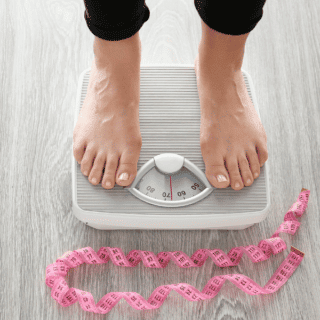 woman on scale with feet being shown and tape measure on the floor