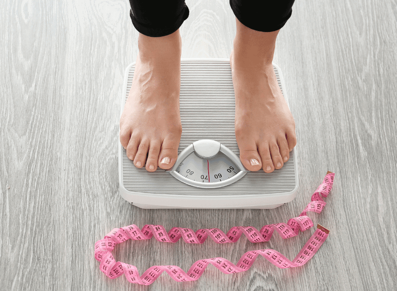 woman on scale with feet being shown and tape measure on the floor