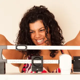 woman happy on scale weighing herself