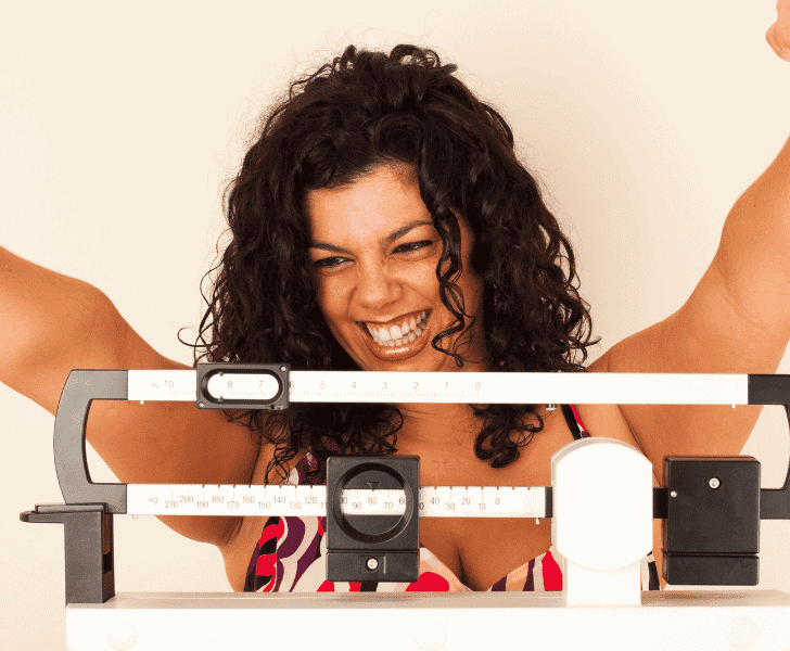 woman happy on scale weighing herself
