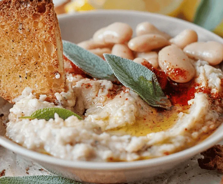 bowl of white bean dip with pita bread