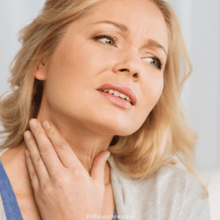 woman in pain with acid reflux holding her throat