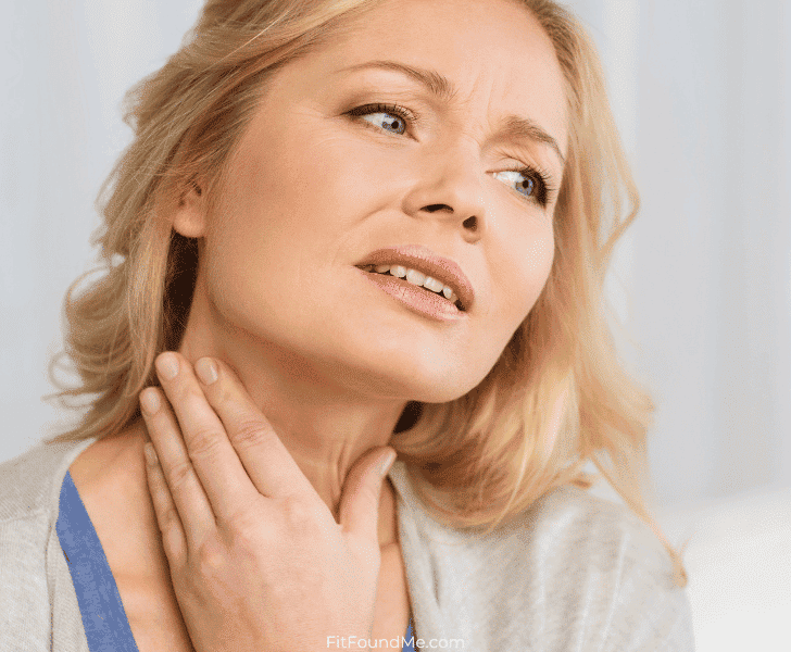 woman in pain with acid reflux holding her throat