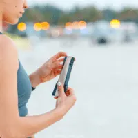 woman dressed in fitness clothing opening protein bar