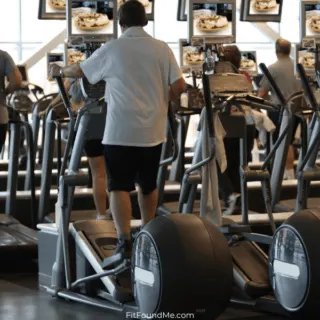 gym full of stairmaster and treadmill machines with men and women working out